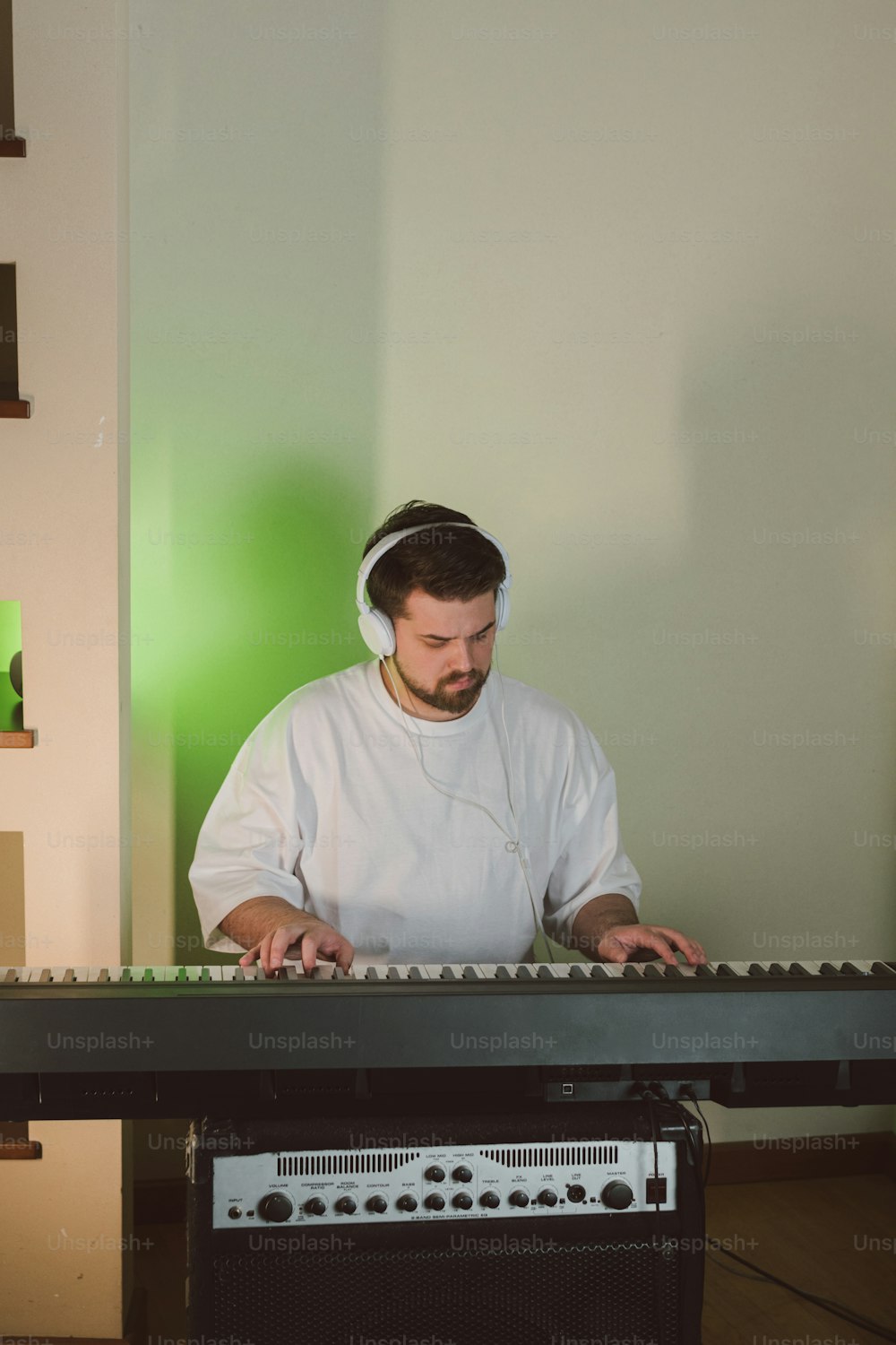 um homem de camisa branca está tocando um teclado