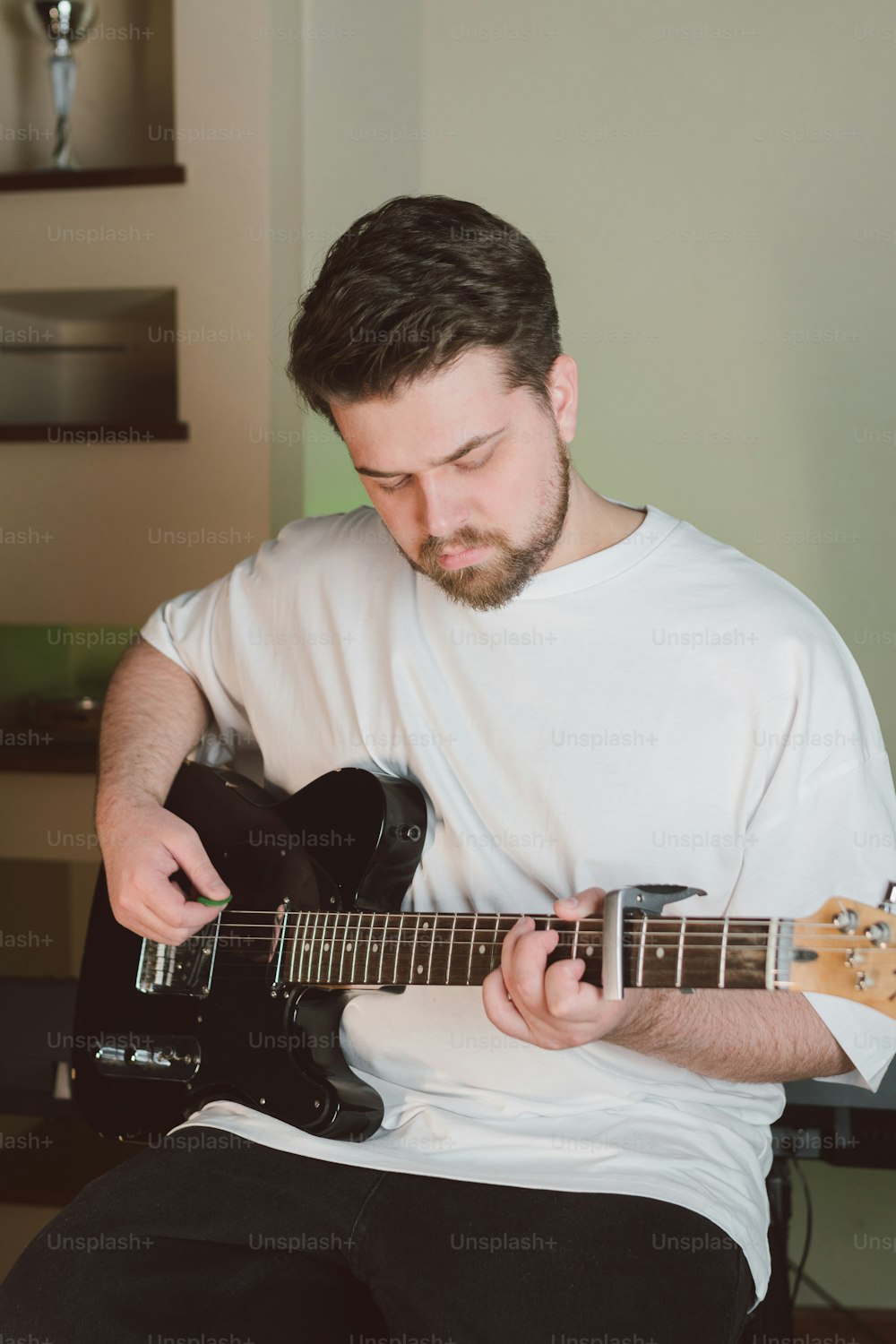 um homem que toca uma guitarra em uma sala