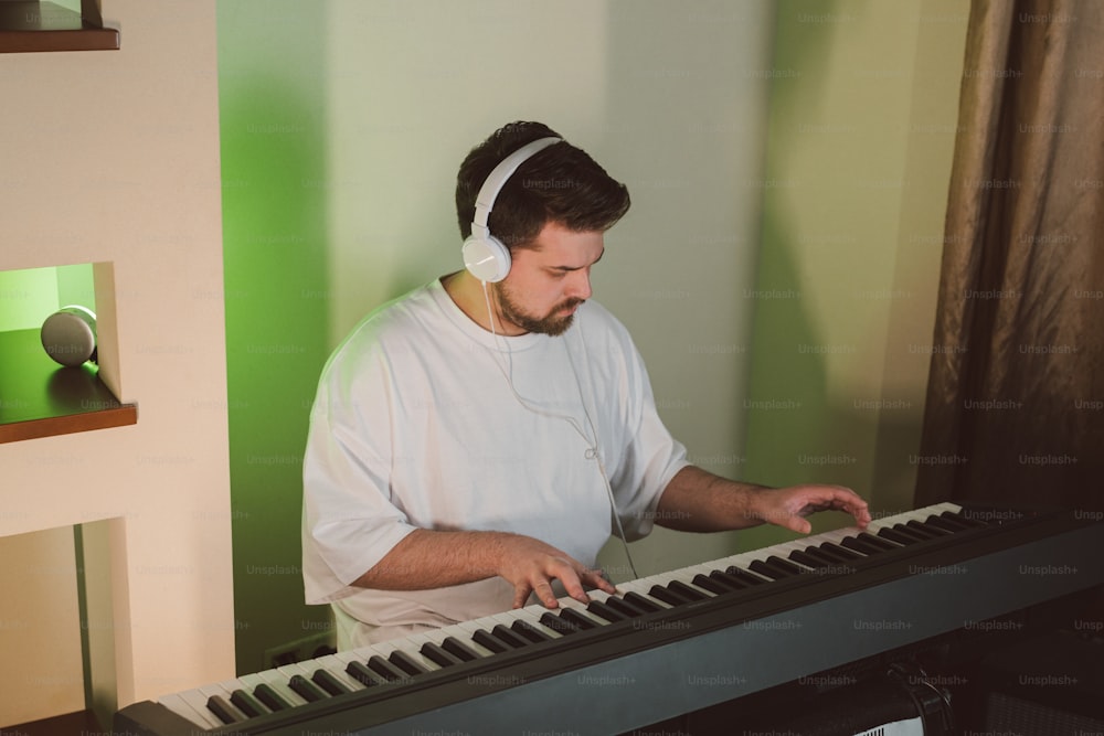 um homem usando fones de ouvido tocando um teclado
