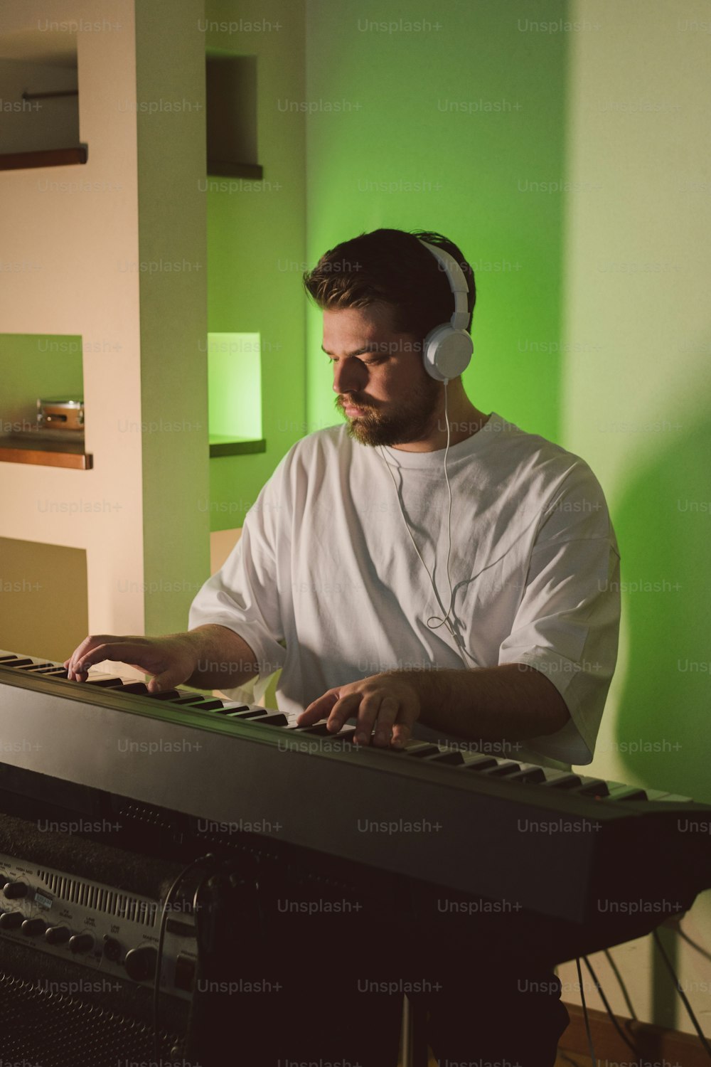 Ein Mann mit Kopfhörern spielt auf einem Keyboard