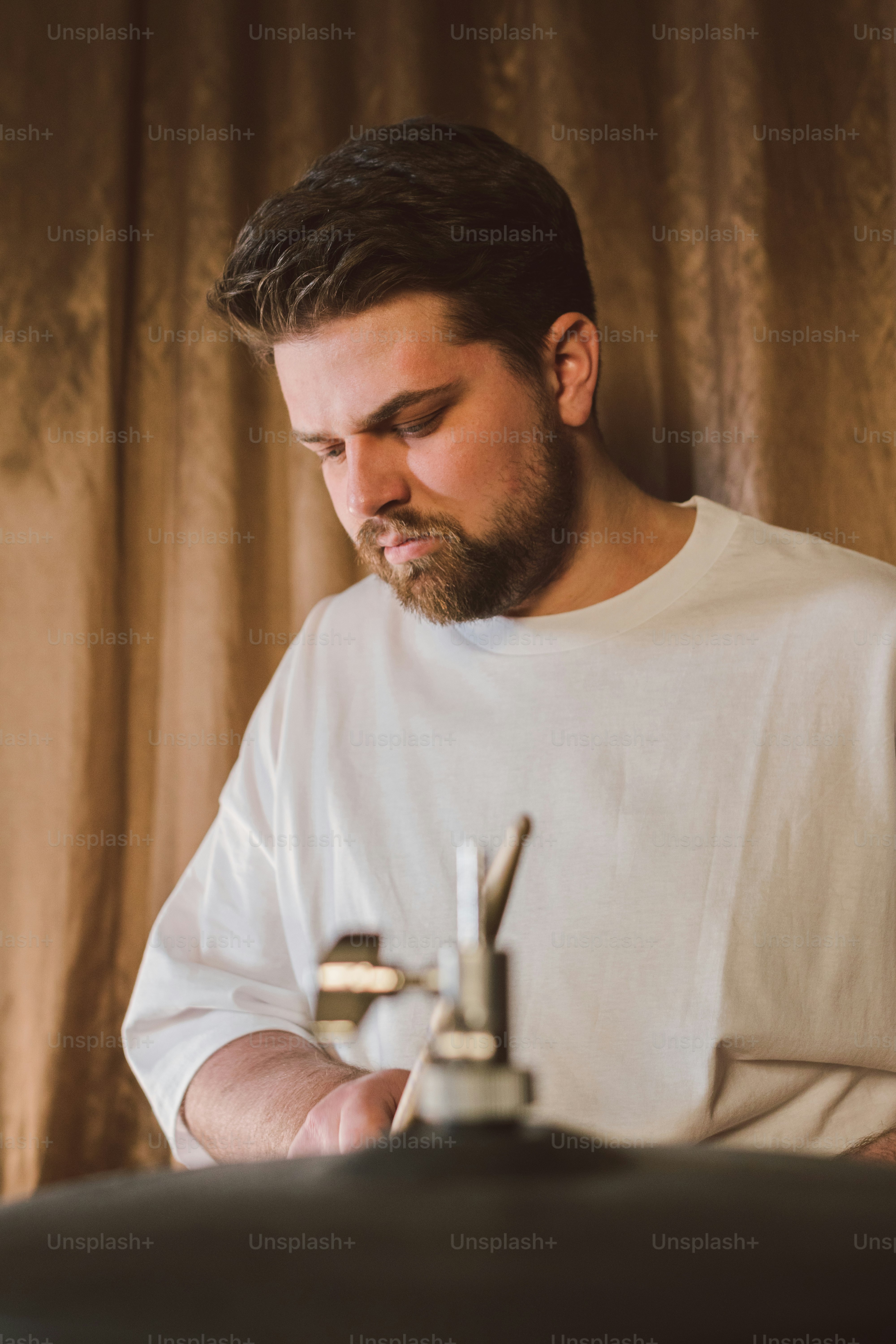 a man in a white shirt is looking at his cell phone