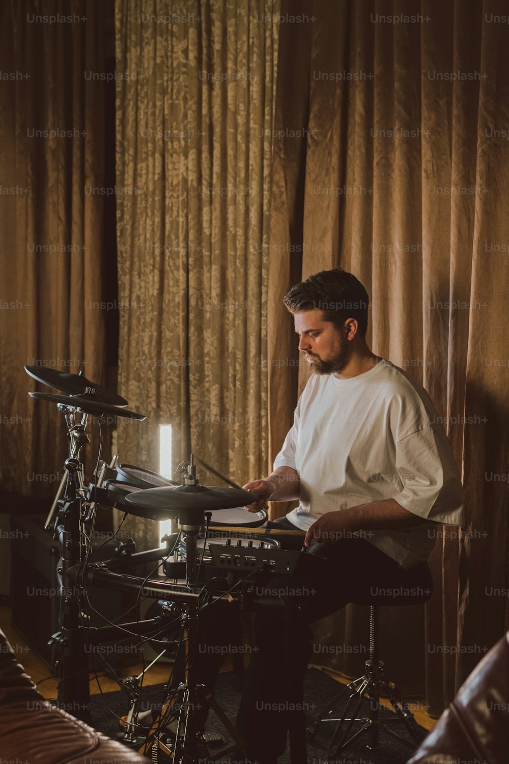 a man sitting in front of a drum set