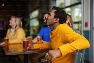 a man sitting at a table with a glass of beer