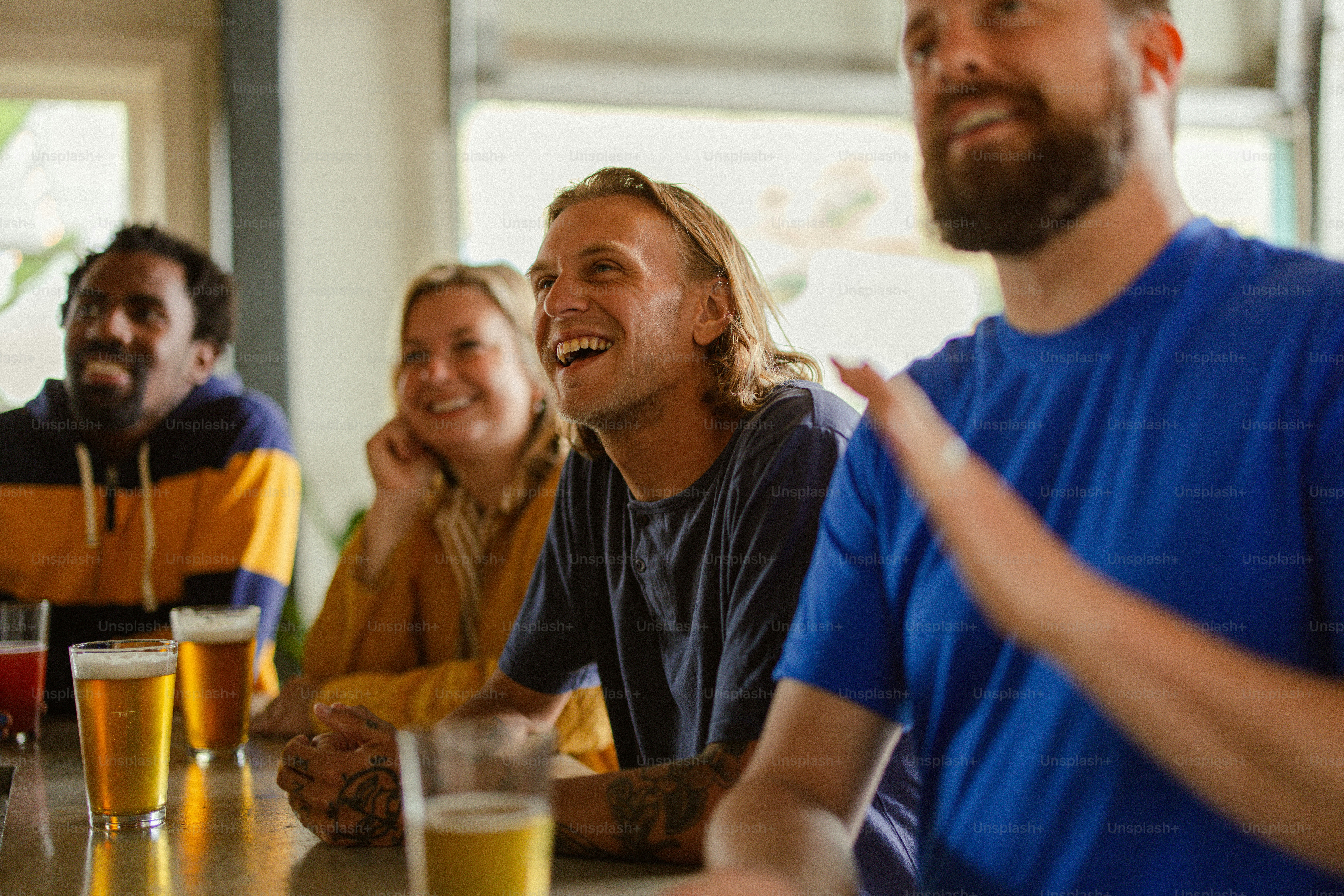 un groupe de personnes assises à une table avec des bières