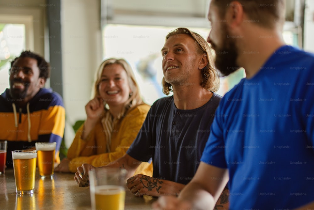 a group of people sitting at a table with beers