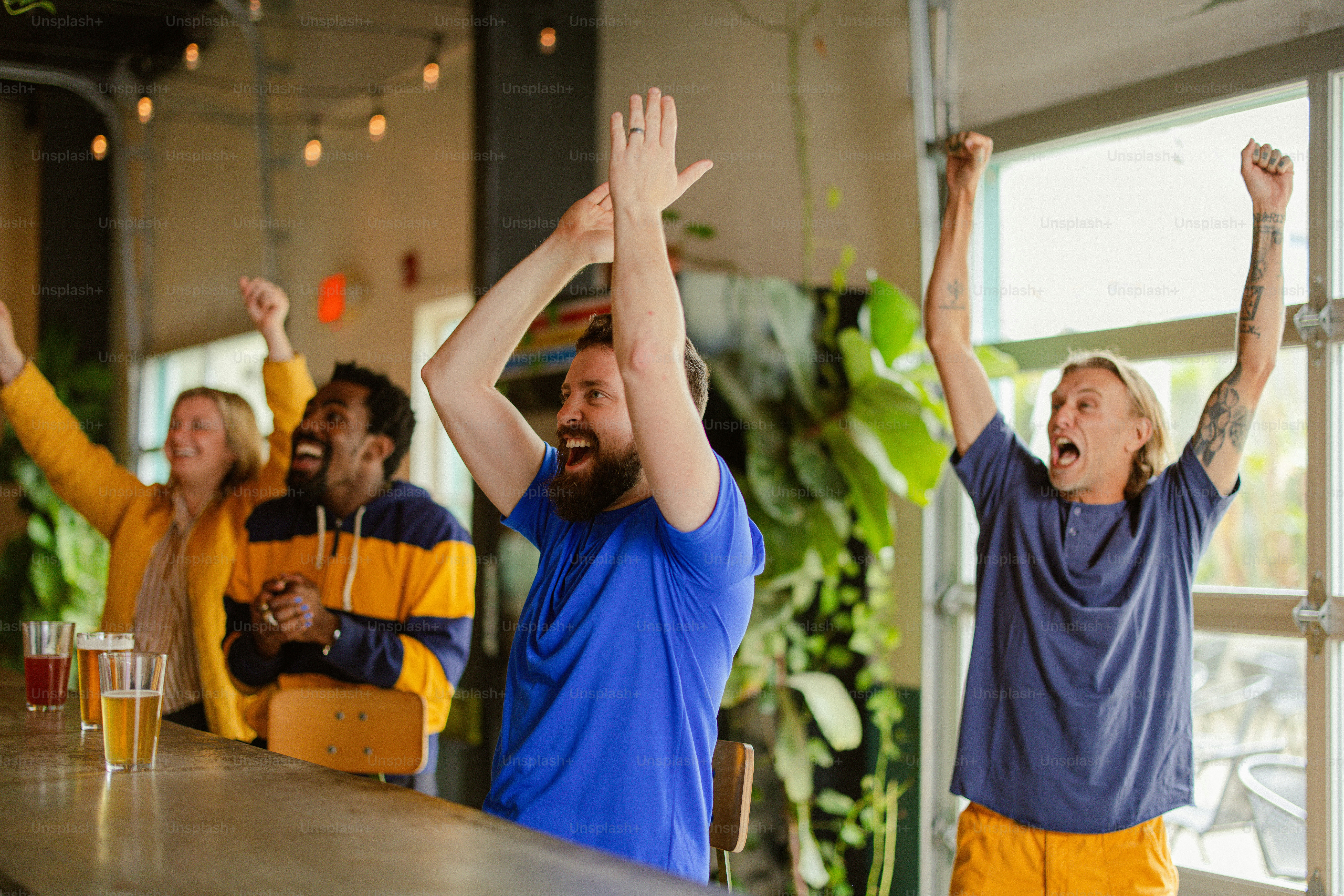 a group of people standing at a bar raising their hands