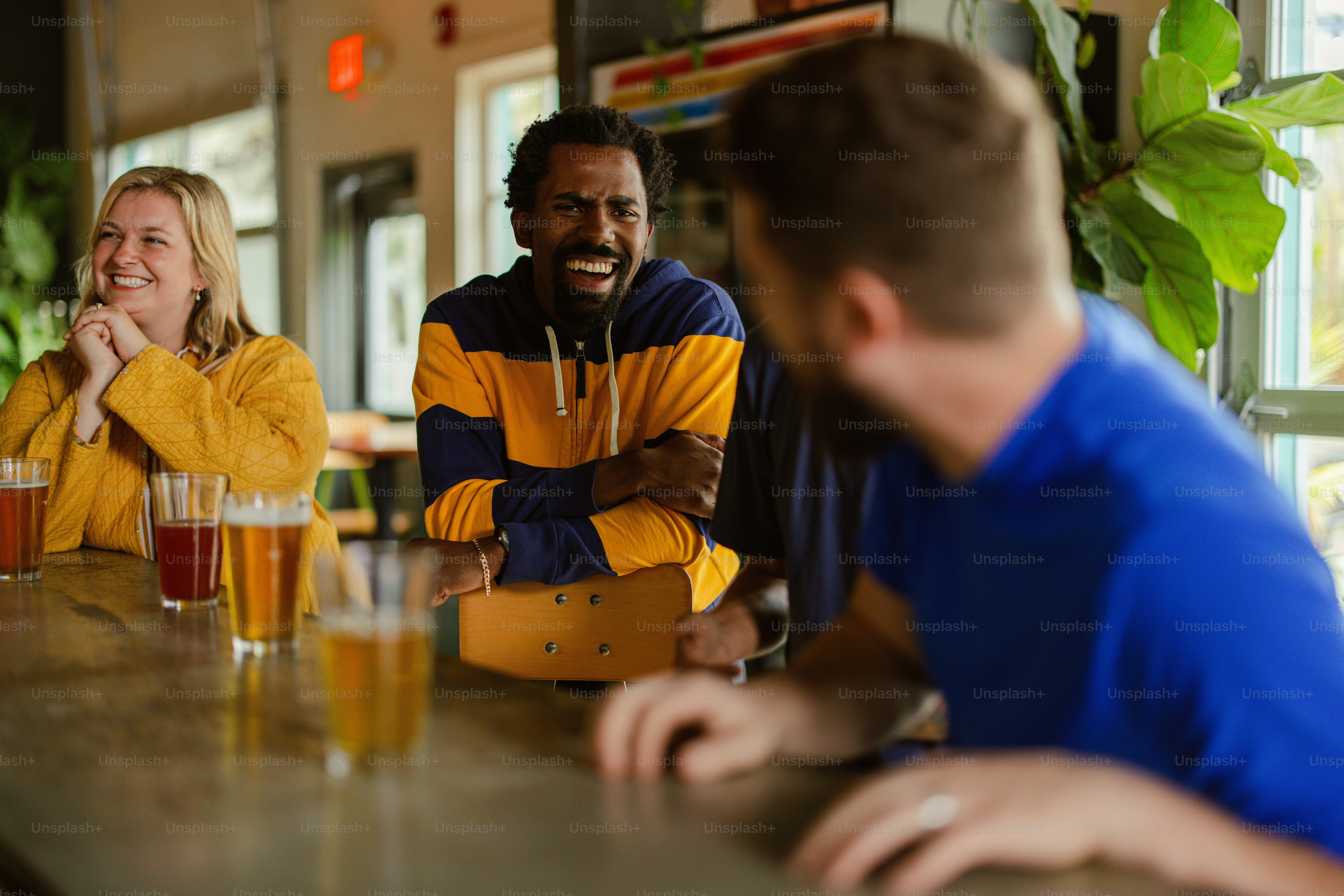a group of people sitting at a bar with beers