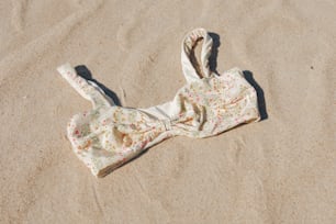 um top de biquíni deitado na areia da praia