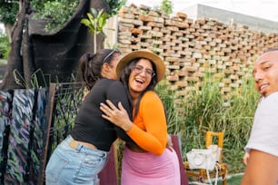 a woman hugging another woman in front of a fence
