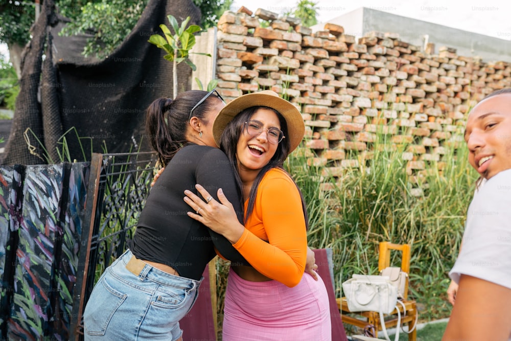 uma mulher abraçando outra mulher em frente a uma cerca