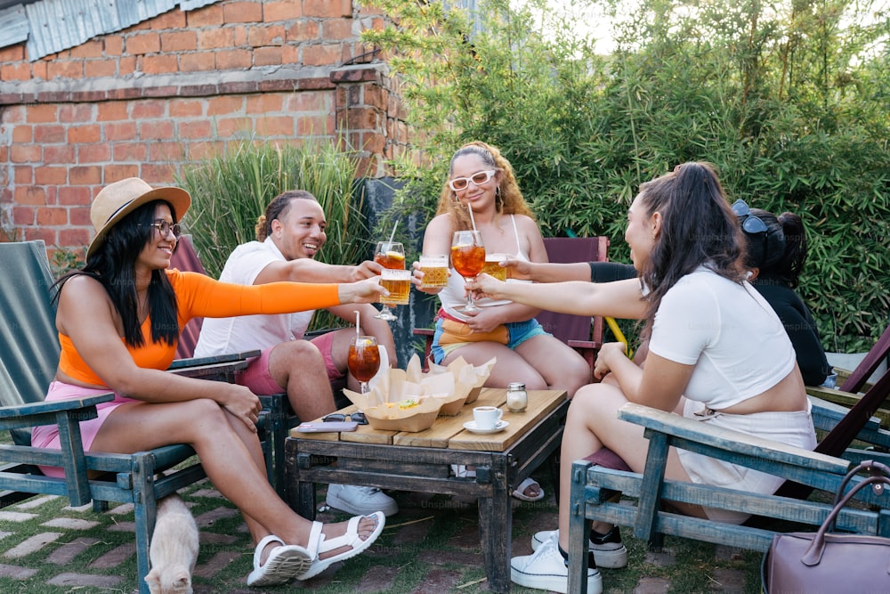 Eine Gruppe von Frauen, die um einen Tisch sitzen und Bier trinken