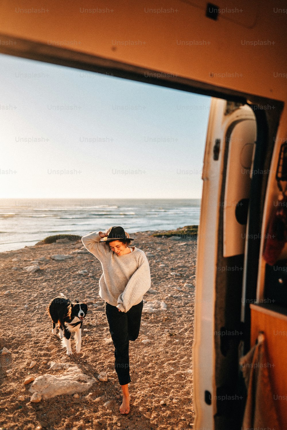 a woman standing on a beach next to a van