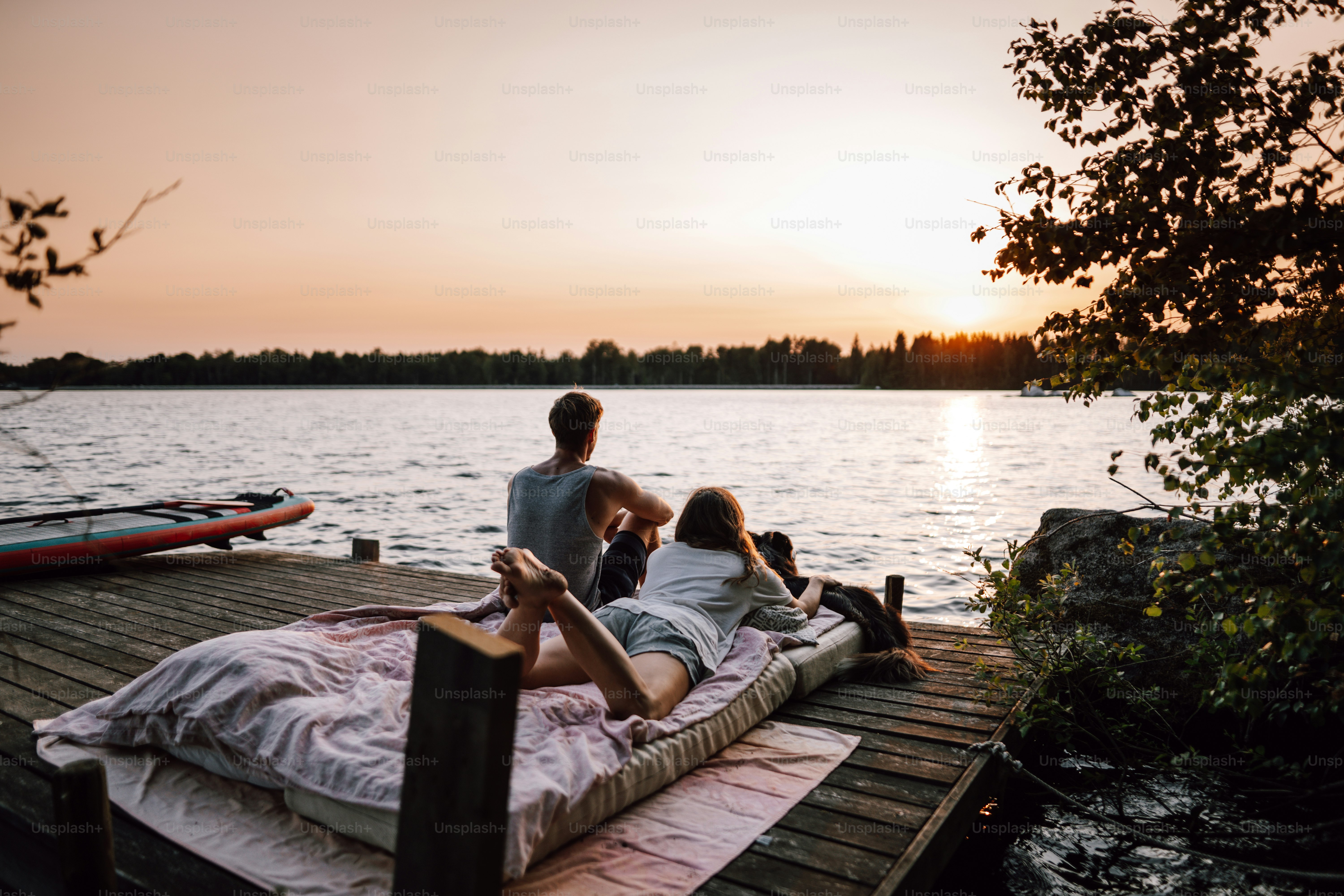 a man and a woman sitting on a bed on a dock