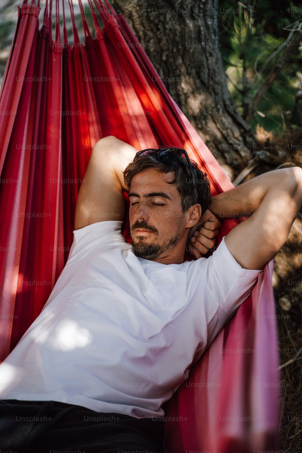 a man laying in a hammock in the shade