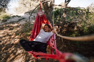 a man sitting in a hammock in the shade