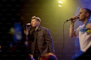 a couple of men standing on top of a stage