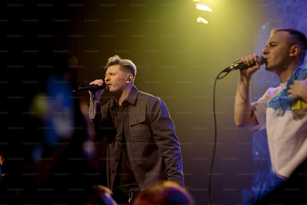 a couple of men standing on top of a stage