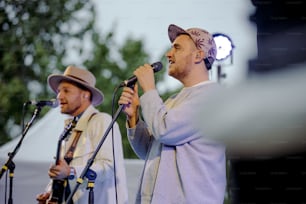 a couple of men standing next to each other on a stage