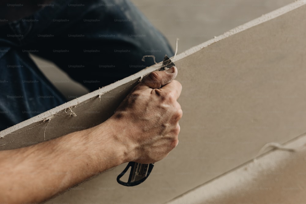 uma pessoa segurando um pedaço de concreto com as mãos