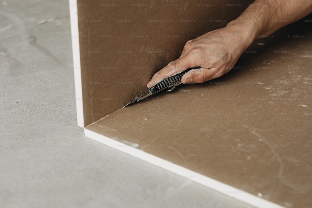 a person cutting a piece of cardboard with a pair of scissors