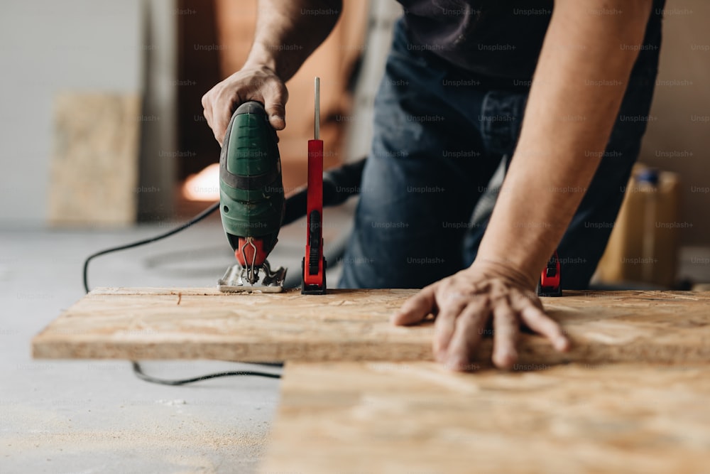 a man sanding a piece of wood with a sander