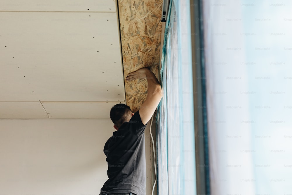 a man working on a wall in a room