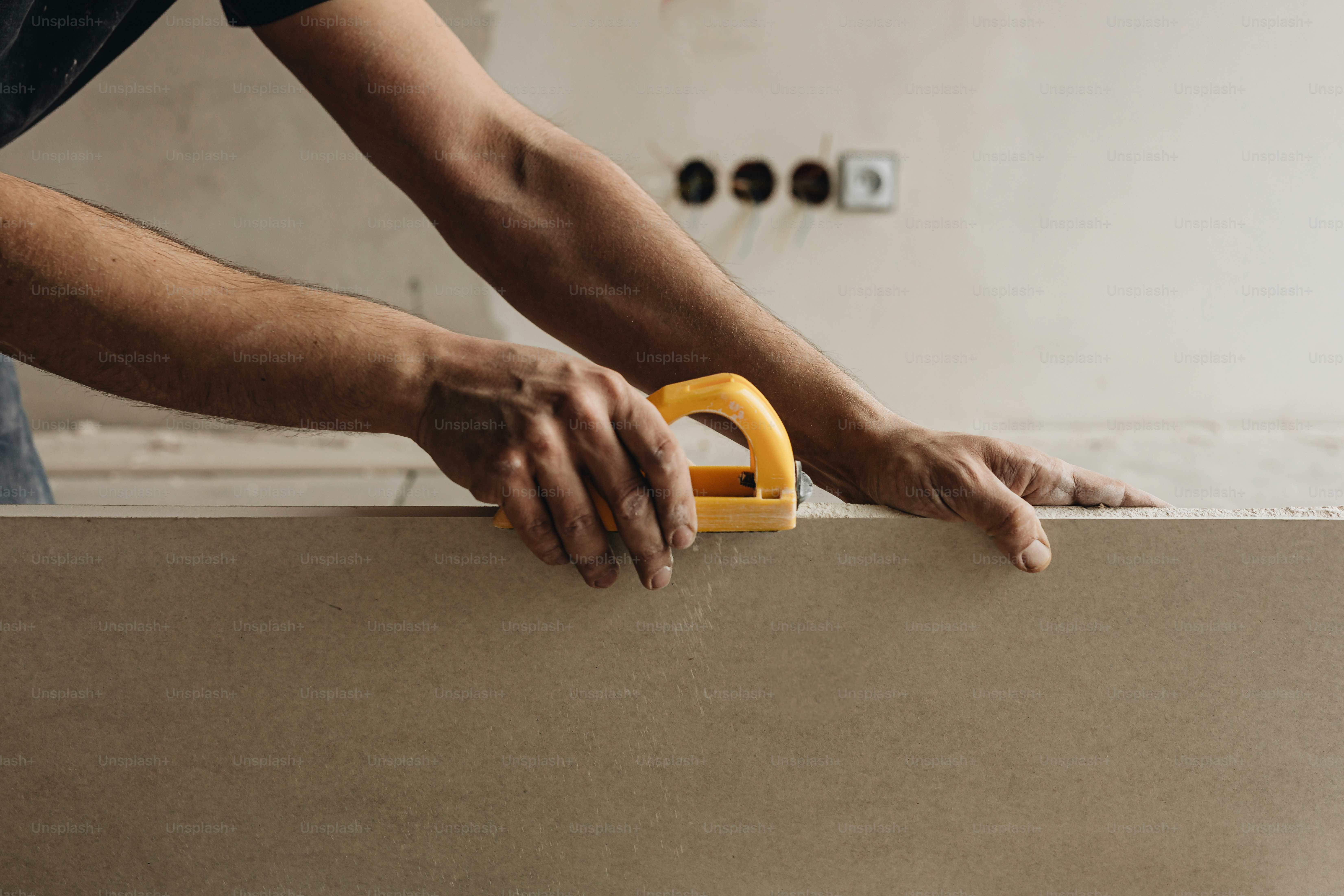a person holding a piece of cardboard with a pair of scissors