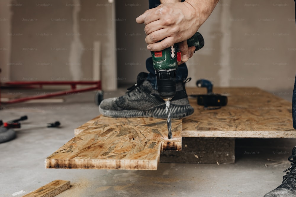 a man using a drill to drill a piece of wood