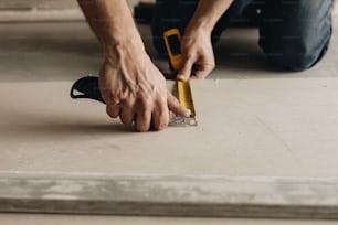 a man with a measuring tape on the floor