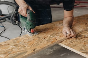 Un hombre usando una herramienta eléctrica en un trozo de madera