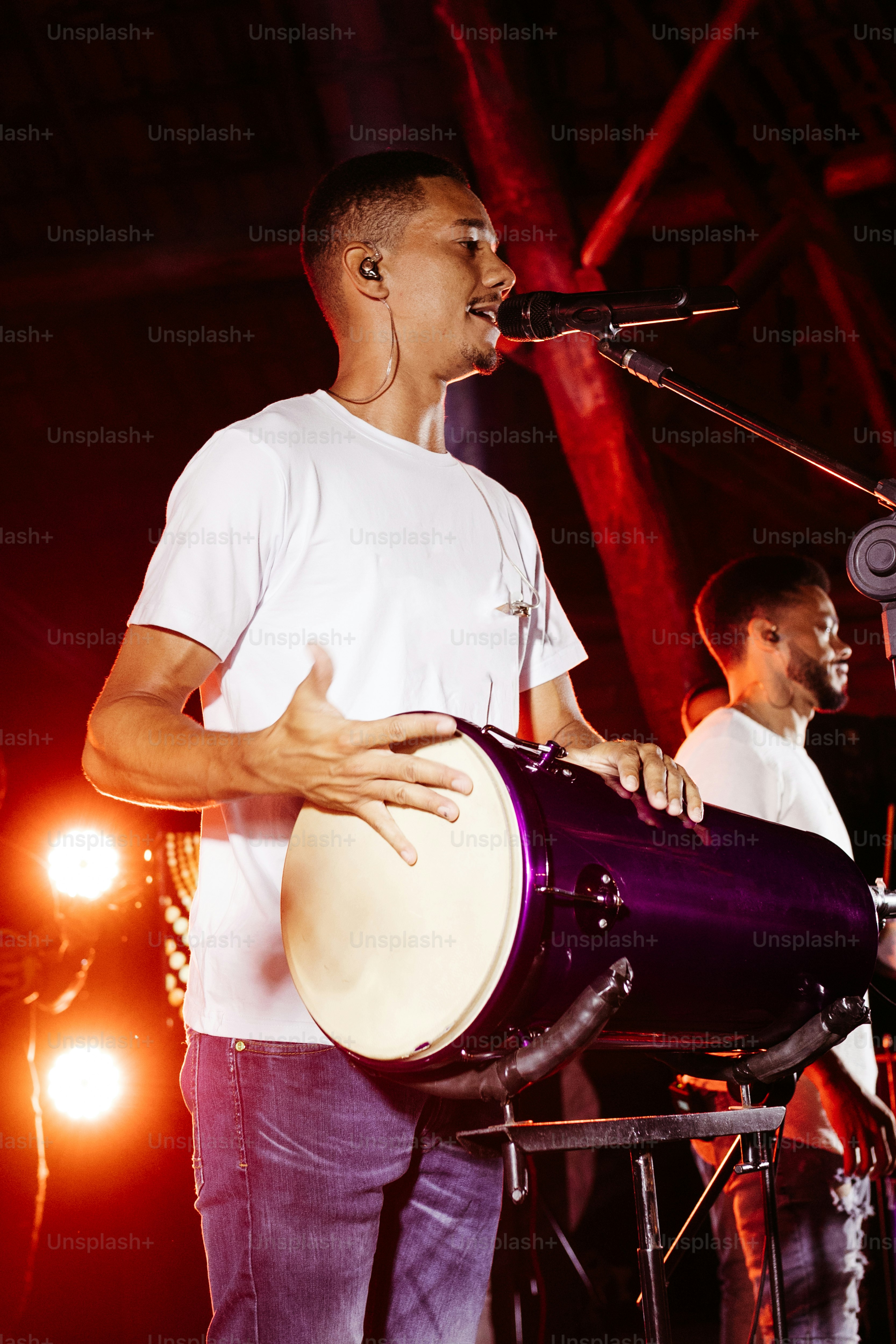 a man standing on a stage with a drum