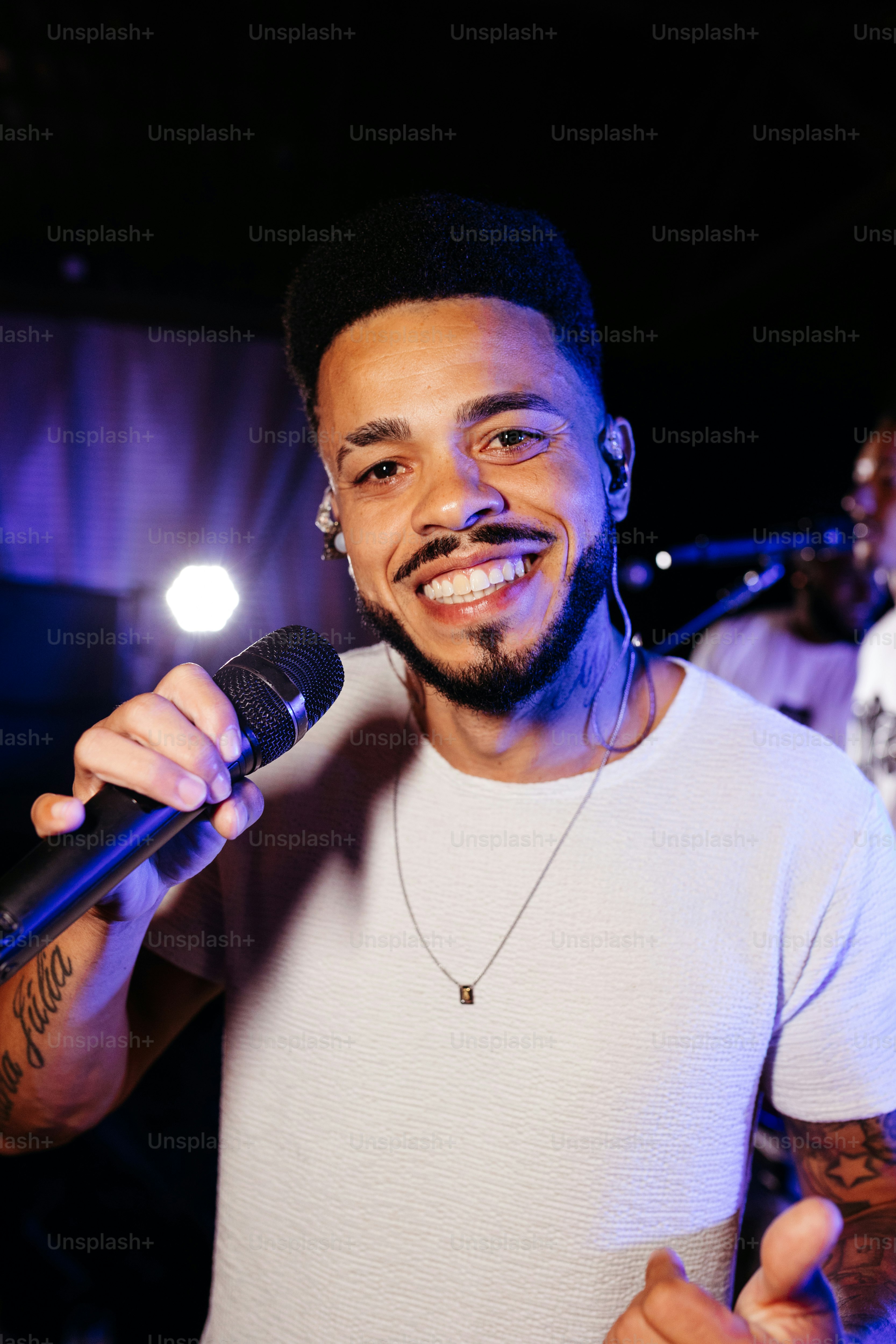 a man holding a microphone and giving a thumbs up