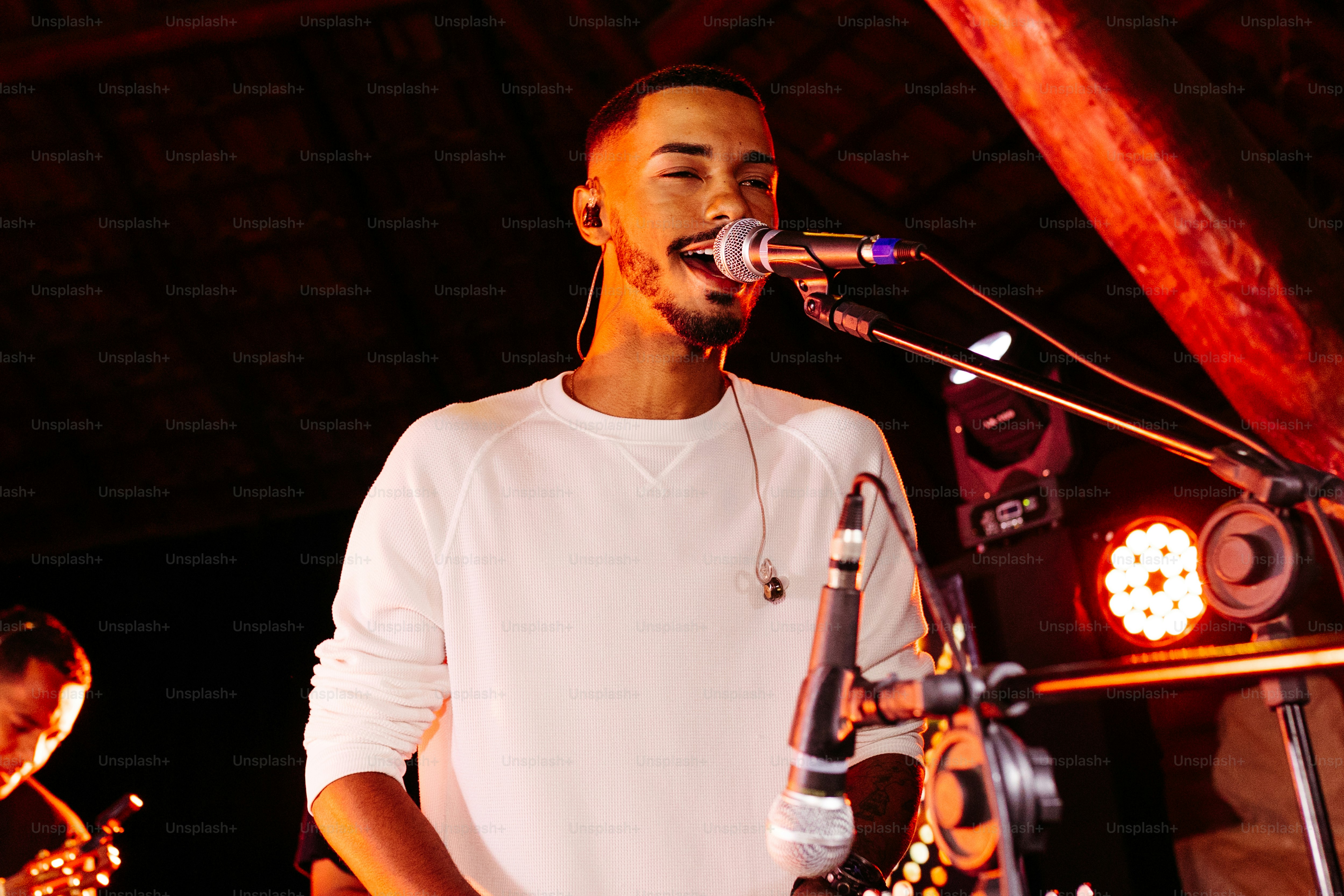 um homem ao lado de um microfone em um palco