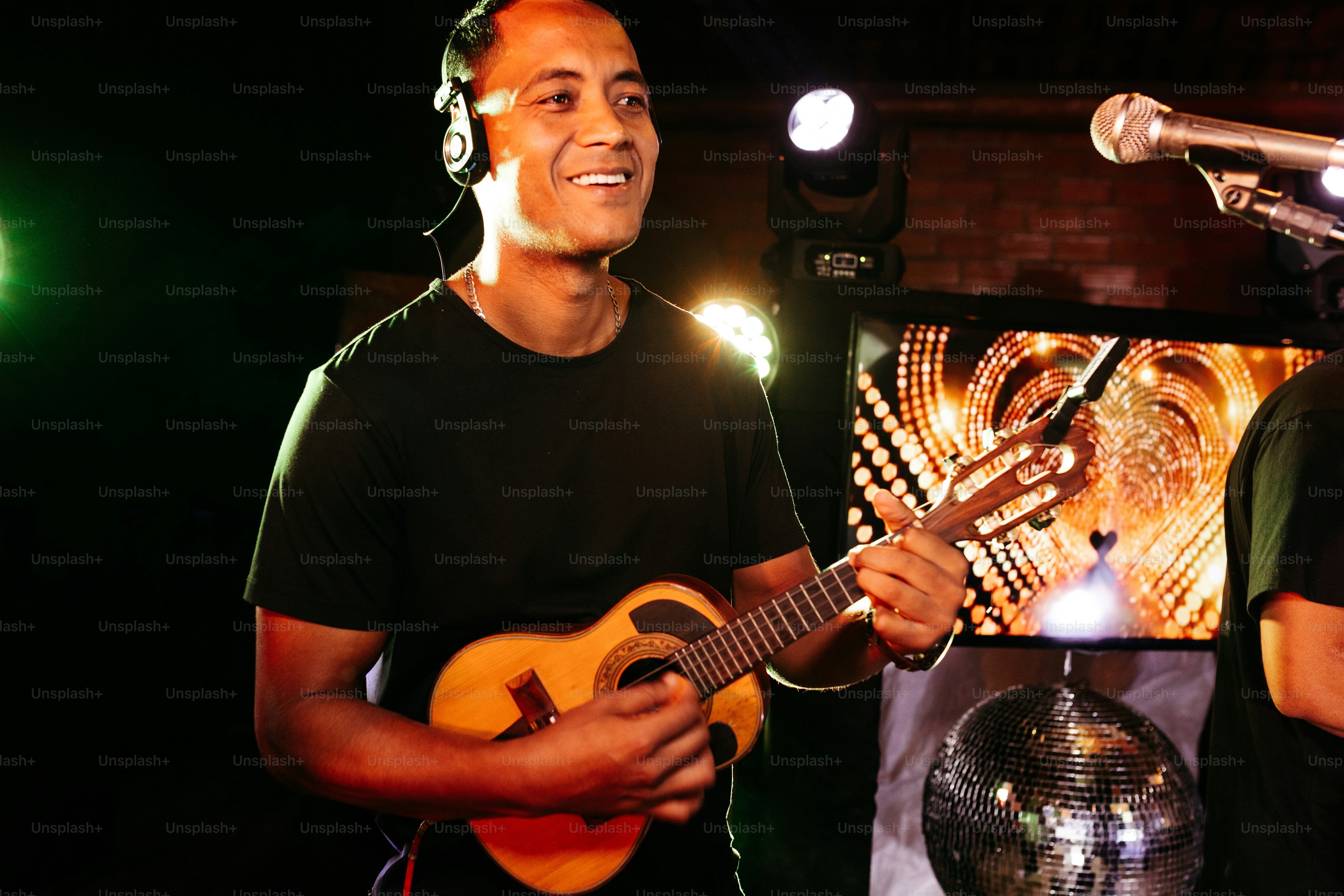 a man holding a guitar in front of a microphone