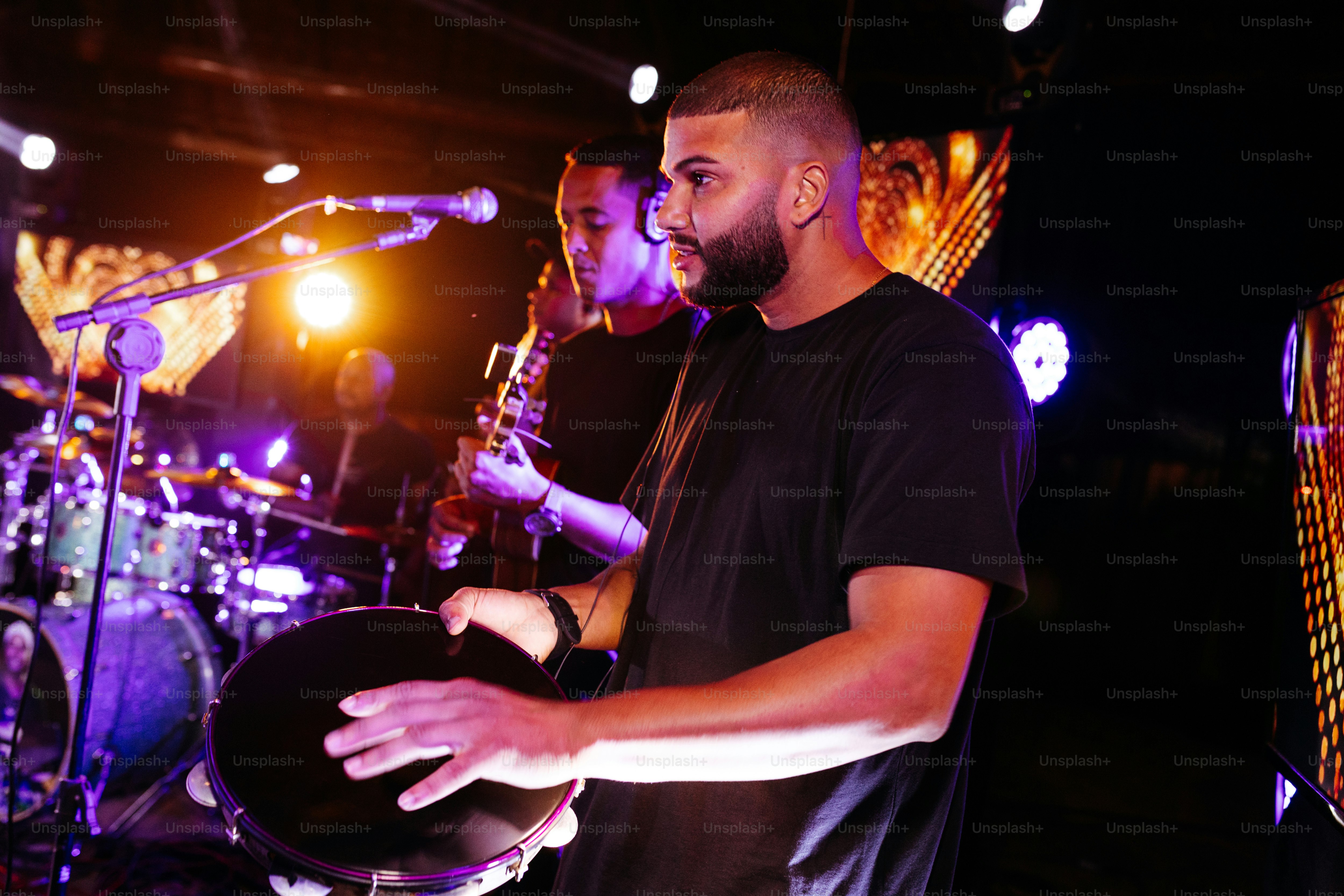 a man holding a drum in front of a microphone
