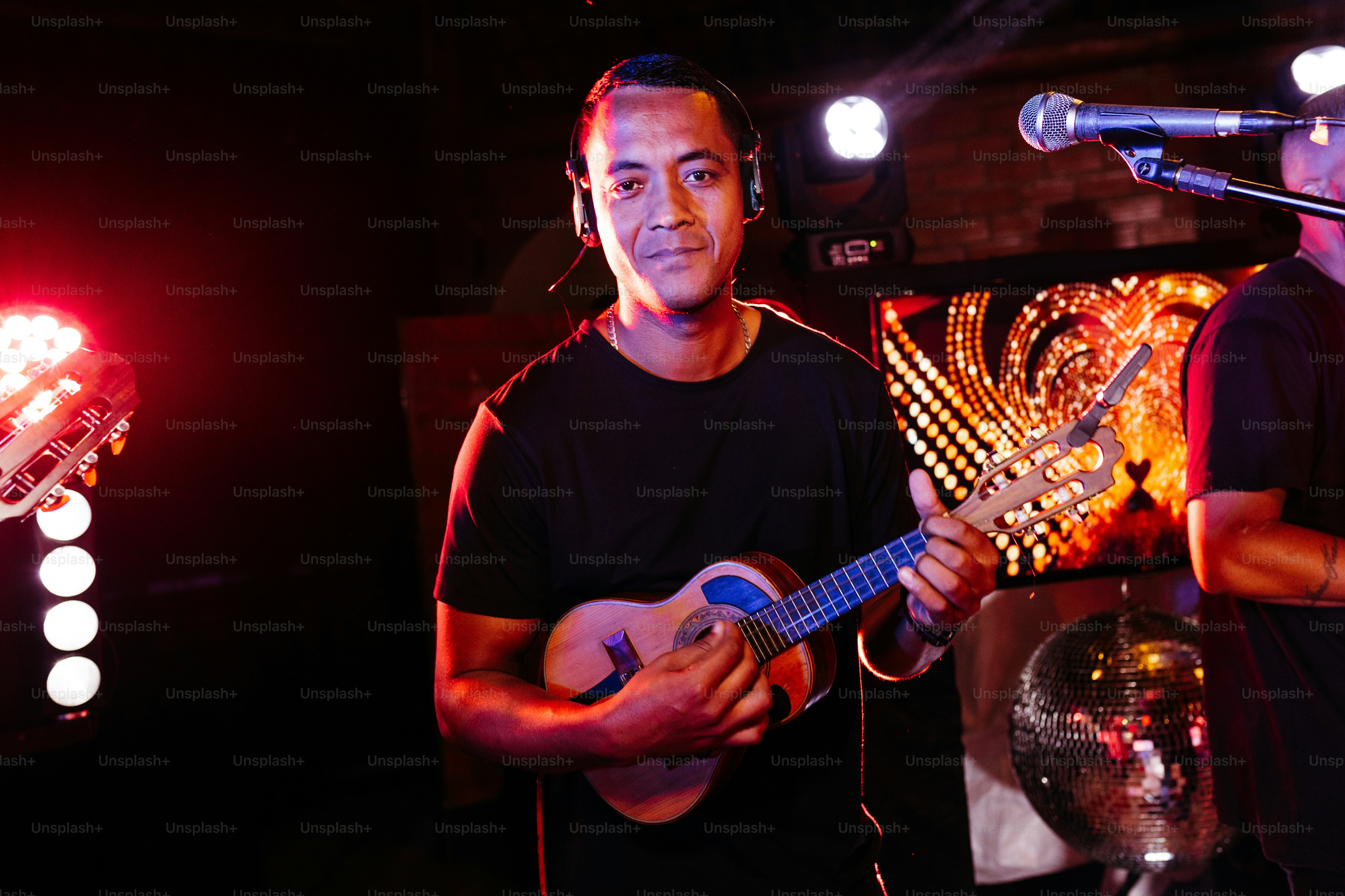 a man holding a guitar in front of a microphone