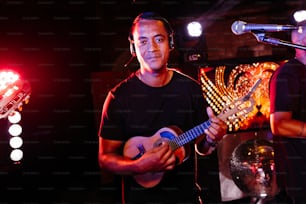 a man holding a guitar in front of a microphone