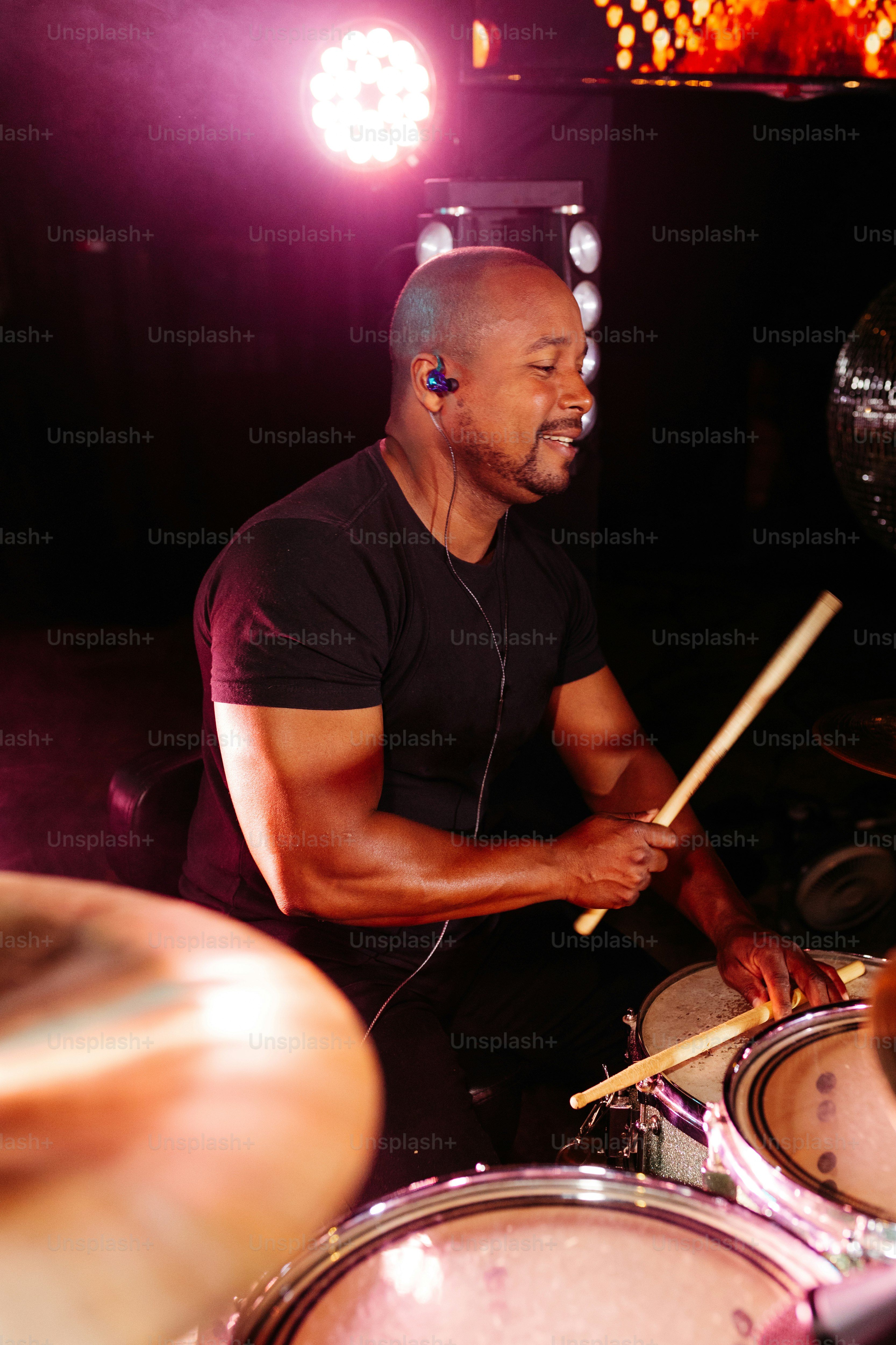 a man playing drums in a dark room