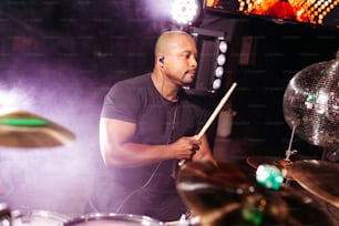 a man playing drums in front of a stage