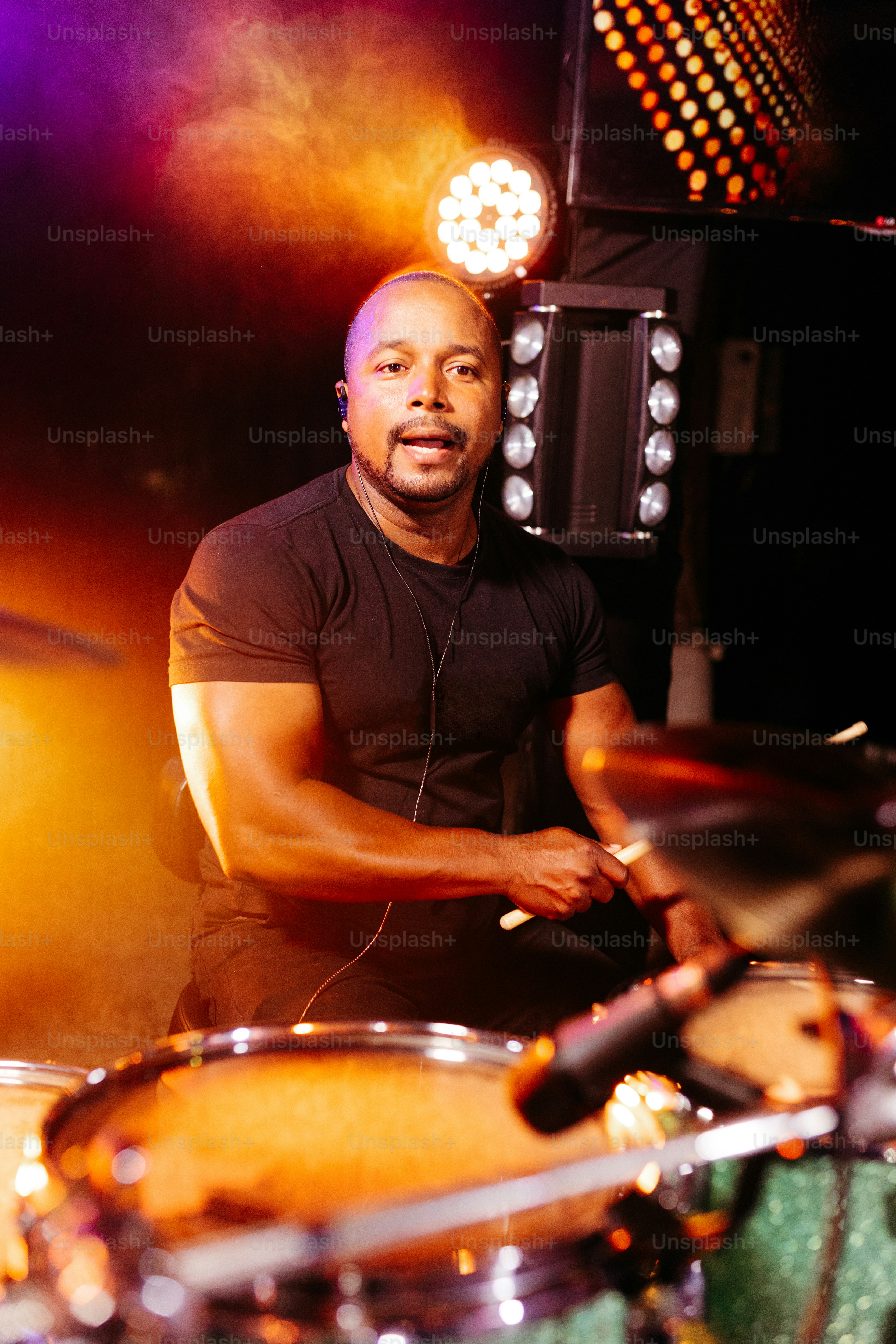 a man that is sitting in front of a drum set