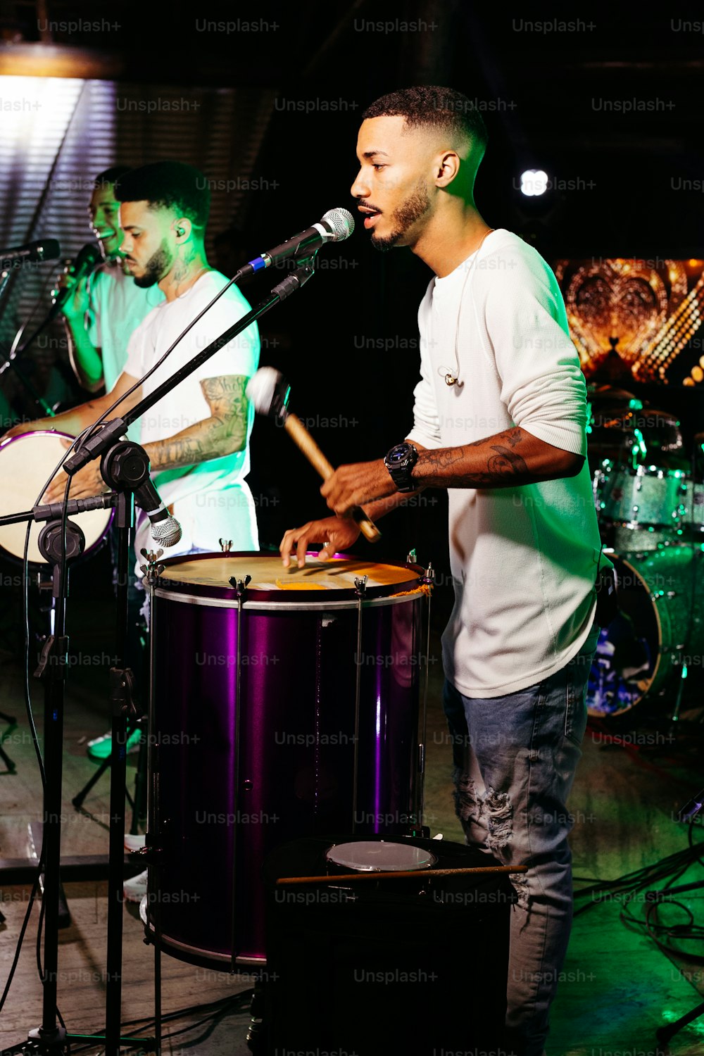 a man standing next to a drum on a stage