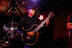 a man playing a guitar in a dark room