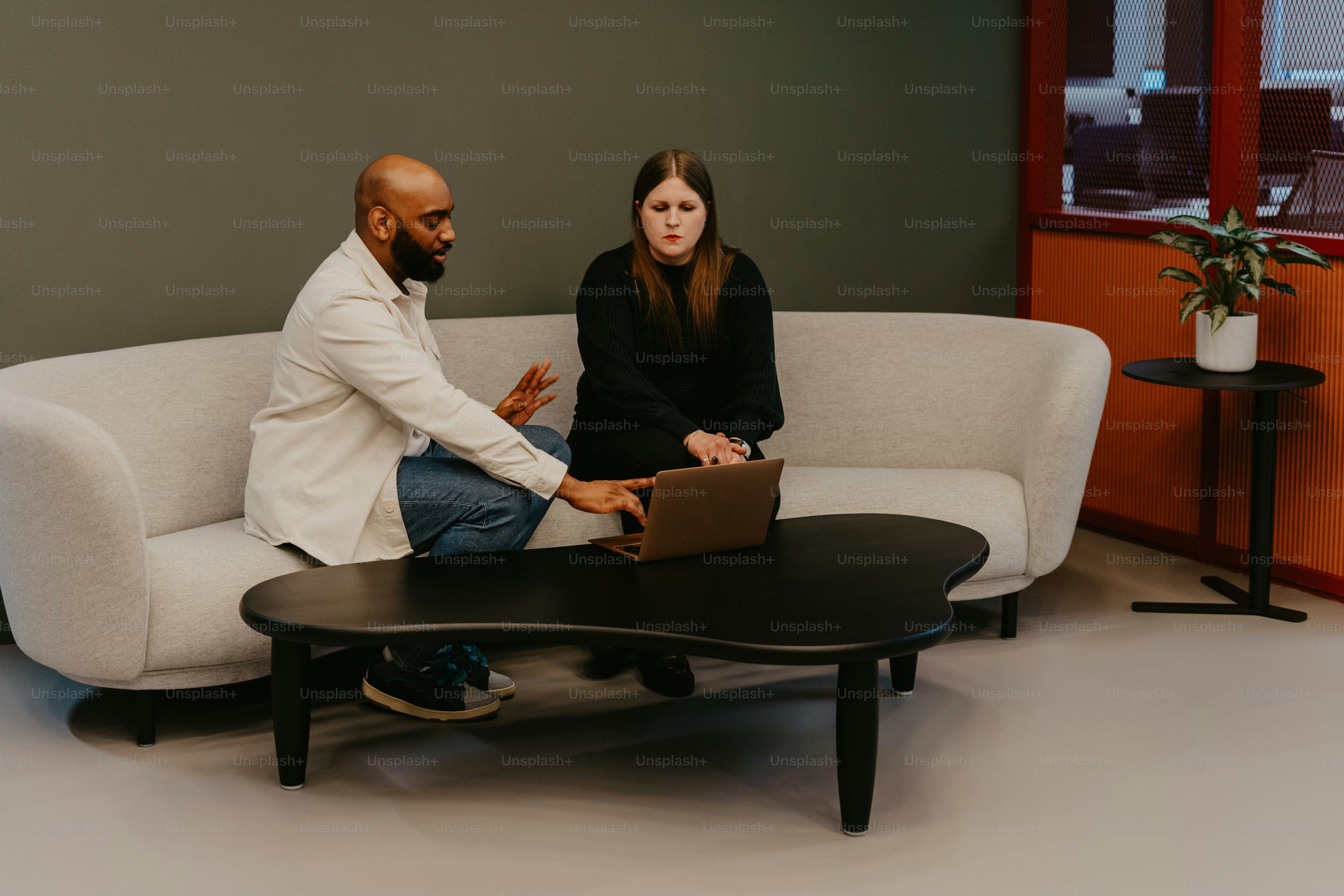 Un hombre y una mujer sentados en un sofá hablando