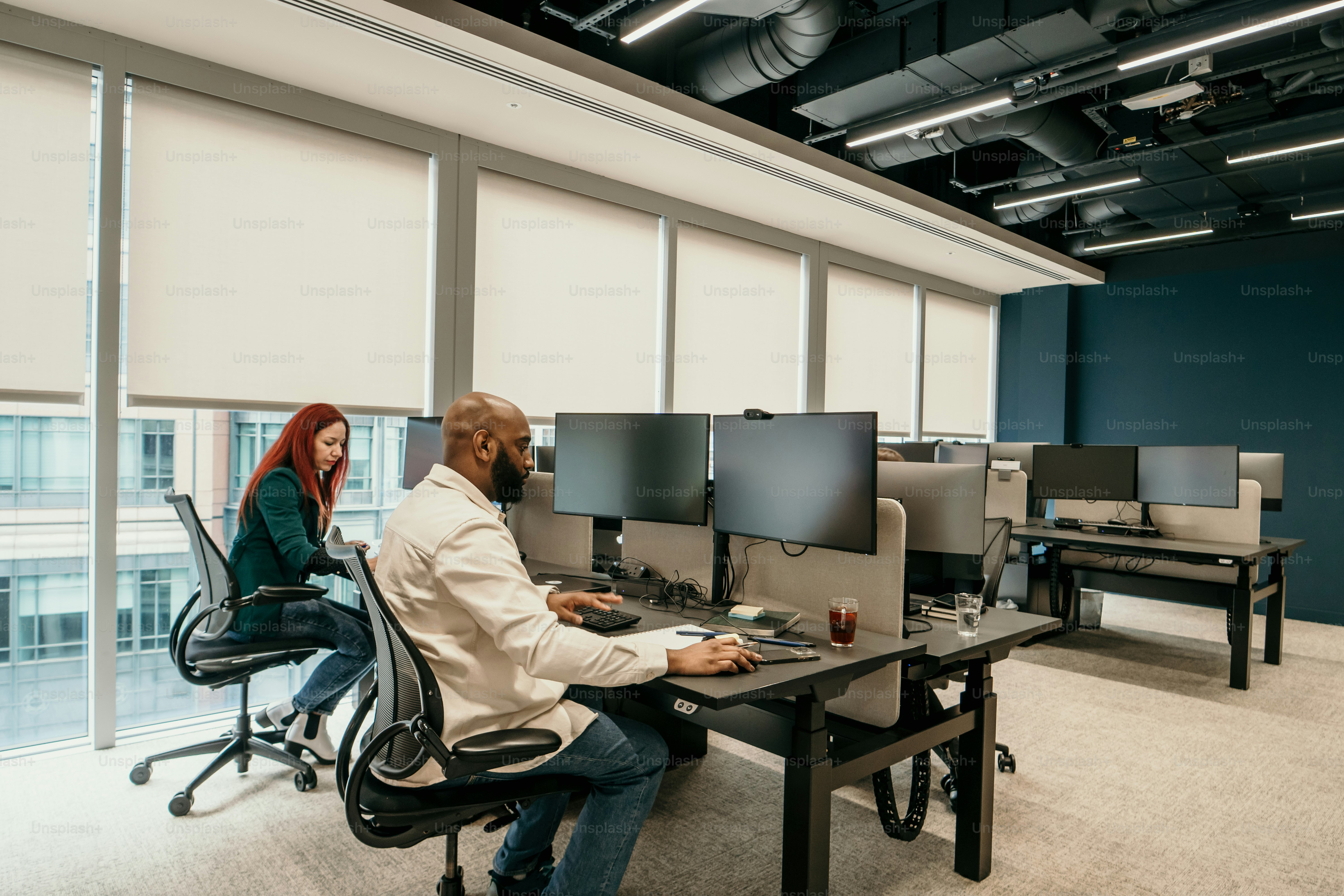 a man and a woman sitting at a desk in an office