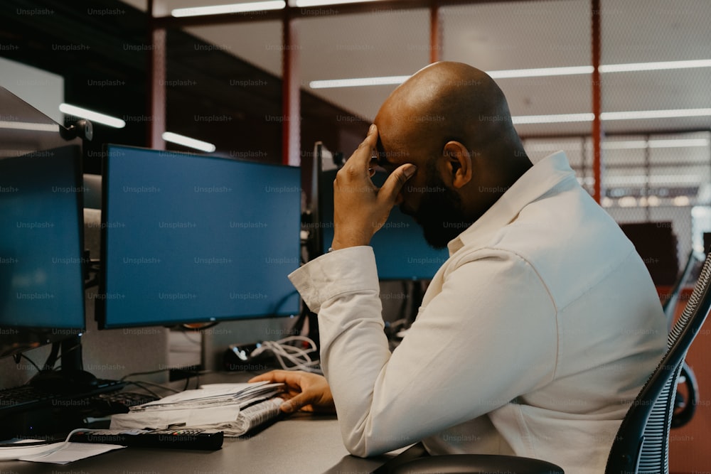 a man sitting at a desk talking on a cell phone