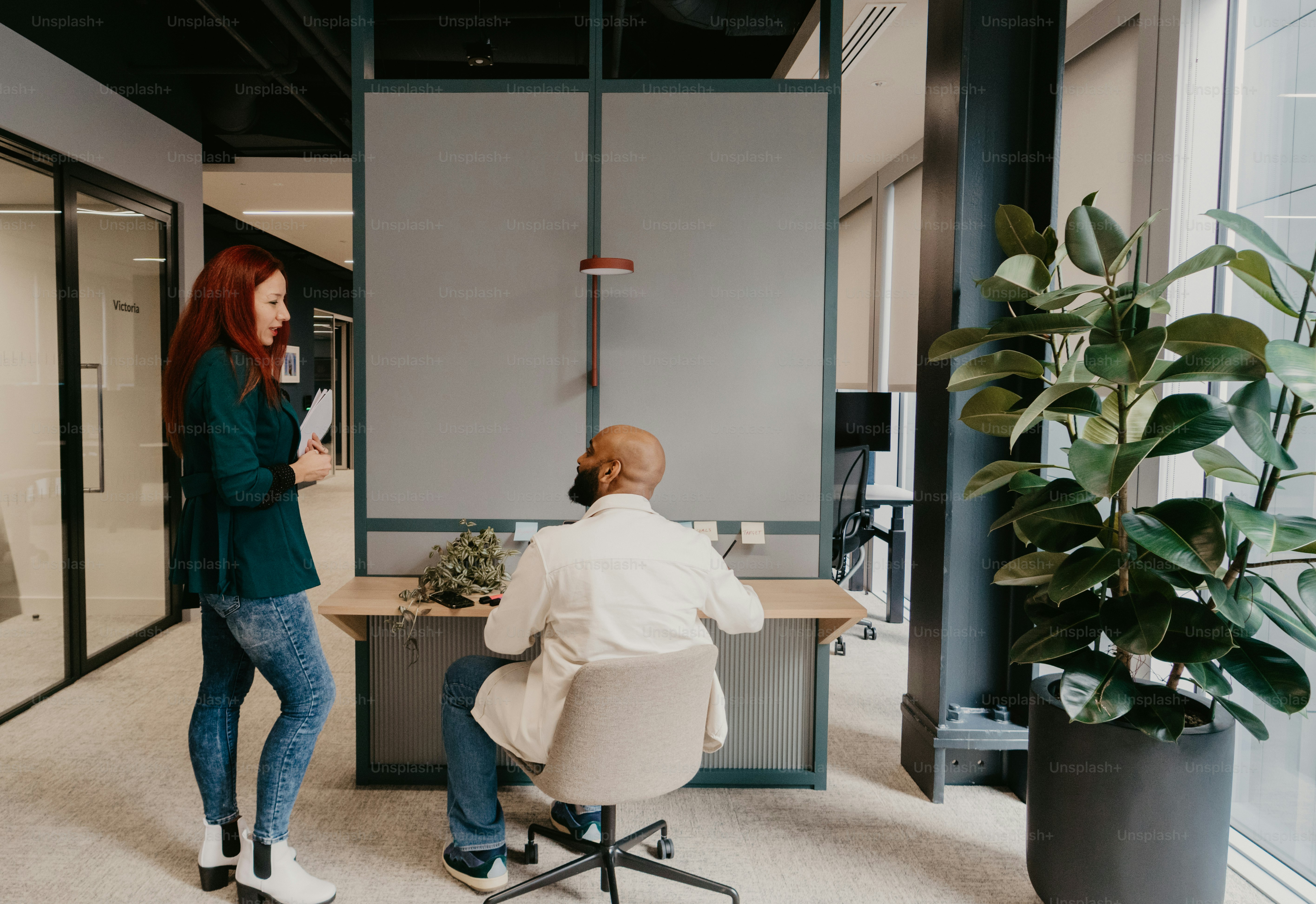 a woman standing in front of a man sitting at a desk