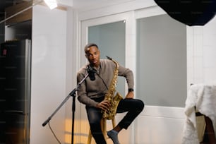 a man sitting on a chair while playing a saxophone