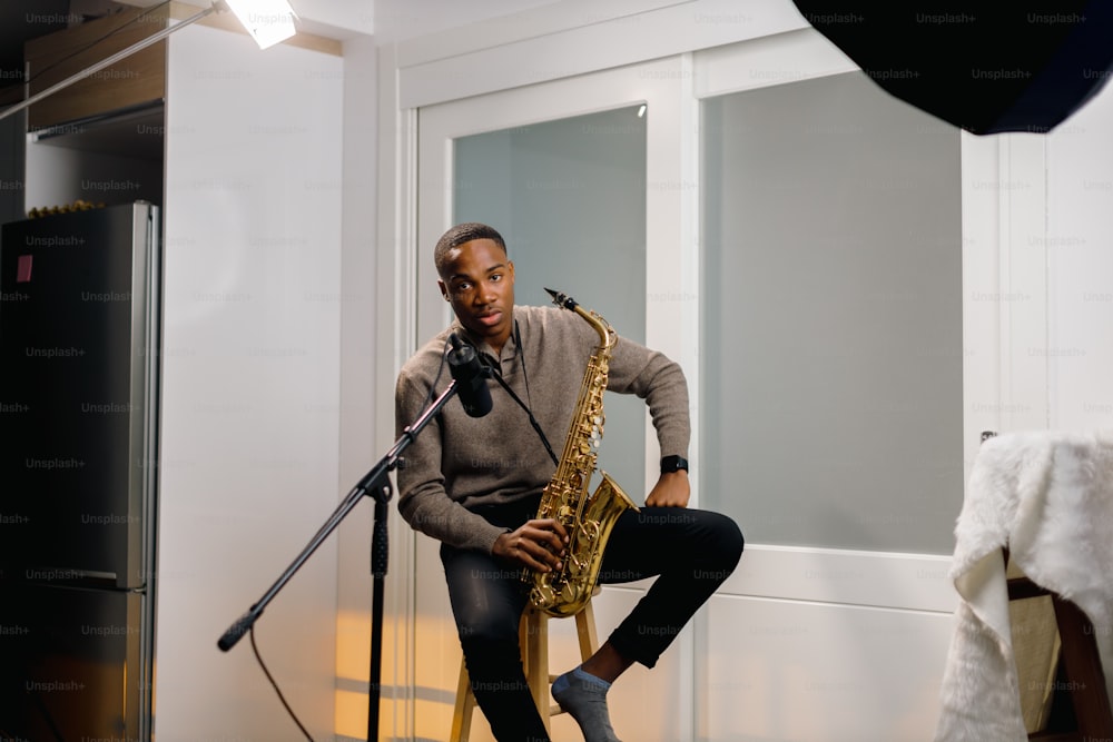 a man sitting on a chair while playing a saxophone