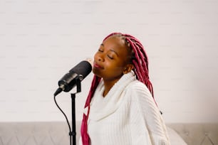 Una mujer con rastas rojas cantando en un micrófono