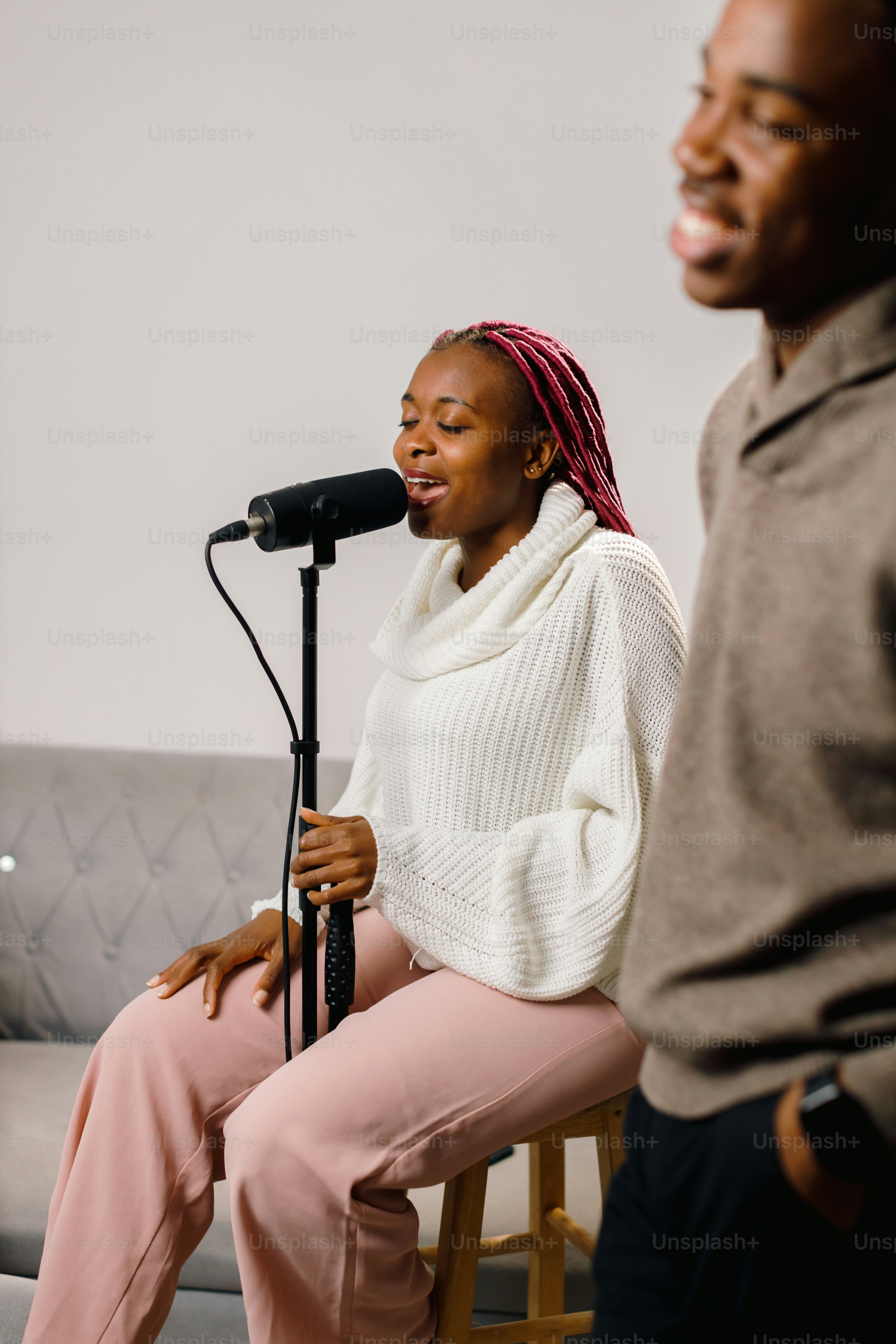 a woman sitting on a stool next to a microphone